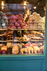 A counter with sweets and pastries through the glass. Meringues, chocolate biscuits, croissants for sale. High quality photo