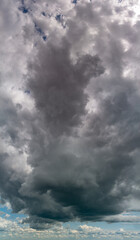 Fototapeta na wymiar Fantastic thunderclouds at sunrise, vertical panorama