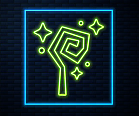 Glowing neon line Magic staff icon isolated on brick wall background. Magic wand, scepter, stick, rod. Vector