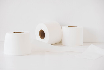 Rolls of white toilet paper on a white background