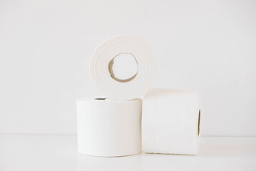 Rolls of white toilet paper on a white background