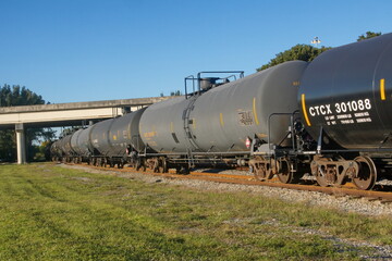 Fototapeta na wymiar Railroad tank cars parked on a track under a bridge in Fort Lauderdale, Florida, USA