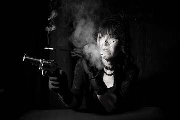 smoking gangster style woman in dramatic lighting holding gun