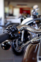 Fototapeta na wymiar Control Buttons On A Chrome Motorcycle Handlebar At Motorbike Showroom 