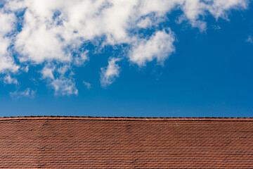 Red roof on cloudy sky