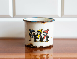 Vintage enameled mug with cartoon penguins