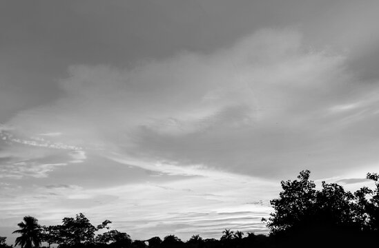 Dramatic monsoon cloud formation in the sky during sunset black and white photo
