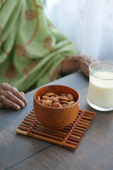 close up senior women hand holding a bowl on almond 