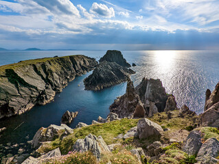 Irish landscape scene with sunlight shining through the clouds above the cliffs and ocean at Malin...