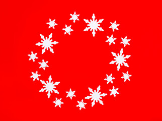 On a bright red background, white snowflakes in the shape of a circle with a place to insert text inside. Place to copy. Christmas concept