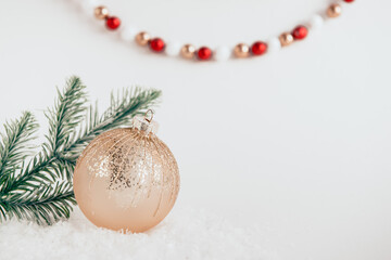 Fototapeta na wymiar festive christmas ball on white background with snow and fir branches