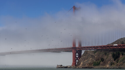 Iconic view Golden Gate with fog and Sailboats