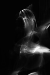 Abstract human silhouette in light trails of light painting with white light beams. Portrait in the...