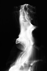 Abstract human silhouette in light trails of light painting with white light beams. Portrait in the style of light painting. Long exposure photo. Image contains noise and motion blur