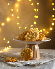 Crispy cheese cookies on a stand against the background of lights, in a rustic style