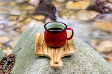 川原で赤いマグカップに淹れたコーヒー