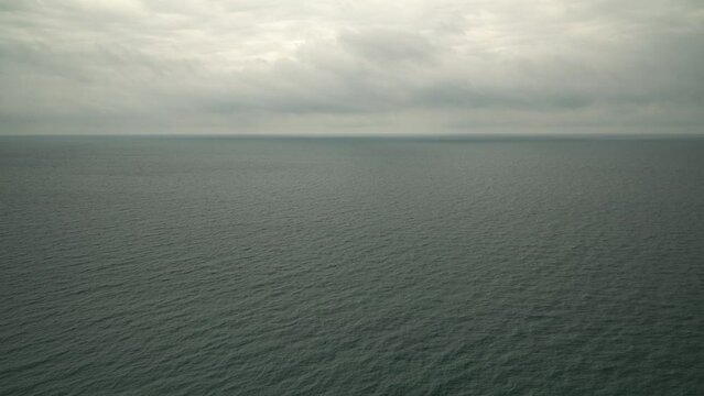 Open sea or ocean on a cloudy day, view from above. Marine background with cloudy sky