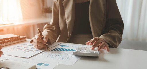 Businesswoman or bookkeeper working Financial investment on calculator, calculate, analyze business and marketing growth on financial document data graph, Accounting, Economic, commercial concept.