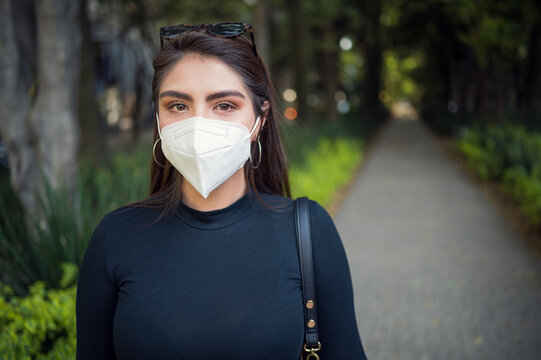 Young latin female in the park with face mask