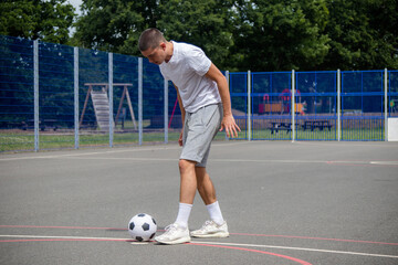 A Nineteen Year Old Teenage Boy Playing Football in A Public Park