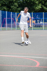 Obraz premium A Nineteen Year Old Teenage Boy Playing Football in A Public Park