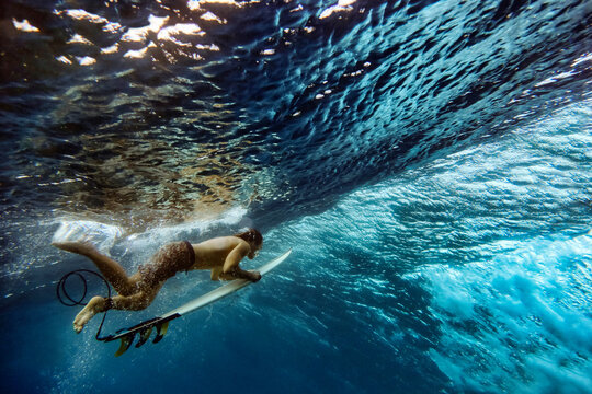 Underwater view of male surfer making duck dive