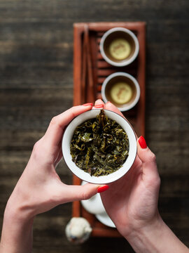 Hands holding Chawan (tea bowl) with green oolong.