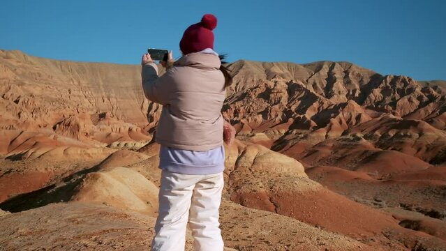Asian woman walking and selfie by phone Red Mountains of Boguty