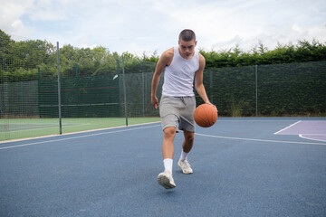 Fototapeta premium A Nineteen Year Old Teenage Boy Playing Basketball