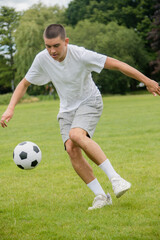 Obraz premium A Nineteen Year Old Teenage Boy Playing Football in A Public Park