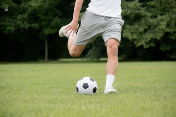 A Nineteen Year Old Teenage Boy Playing Football in A Public Park