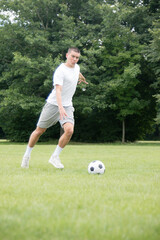 A Nineteen Year Old Teenage Boy Playing Football in A Public Park