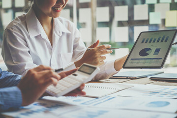 Financial analyst analysis business financial report on digital tablet during discussion at meeting...