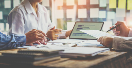 Financial analyst analysis business financial report on digital tablet during discussion at meeting...