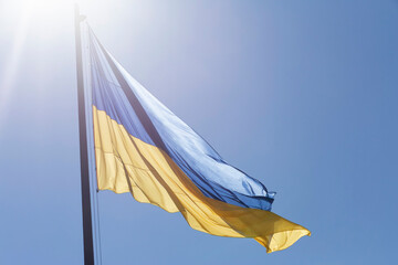 Ukrainian flag on flagpole at sunlight