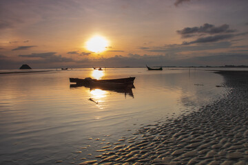 Fototapeta na wymiar Old boat with sunrise in background
