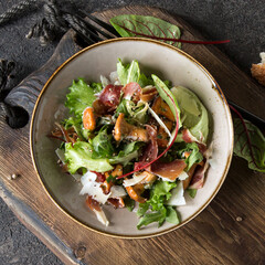 a bowl of salad with arugula, jamon, chanterelles and parmesan on the table © kochabamba