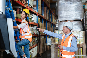 Warehouse worker checking the quantity of storage products on the shelf  in the warehouse.,...