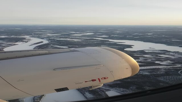 AERIAL, VERTICAL: Passenger airplane flying above gorgeous icy landscape full of meandering rivers, frozen lakes, snowy swamps and frosty trees. Gorgeous white wetlands in Finland during wintertime