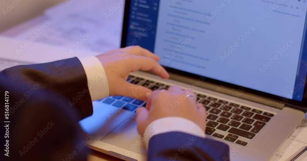 Poster using a laptop on the table. the employee presses the application control buttons. ring on the hand.