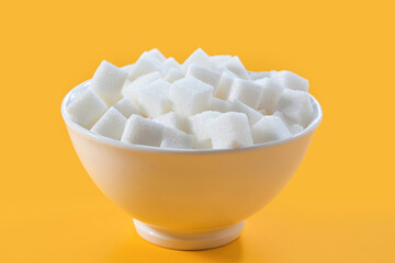 Sugar in cubes in a bowl on a yellow background