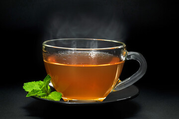 Cup with mint leaves on black background, closeup
