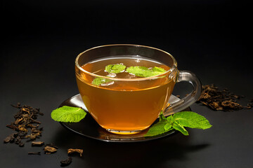 A cup of tea with mint leaves on a dark background