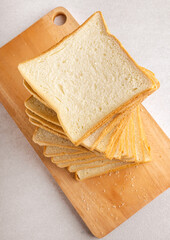Pile of toasted bread slices on cutting board for breakfast. Isolated. Bright background.