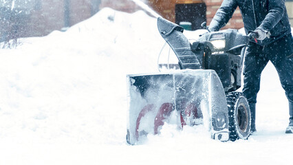 a janitor on a snowplow removes snow in the courtyard of a residential building