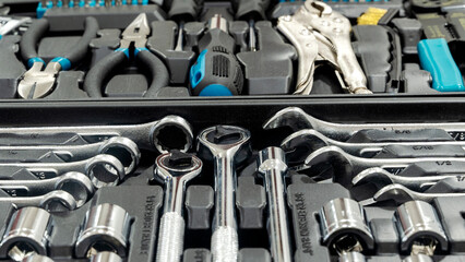 Fototapeta premium Close-up of a box with tools lies on the wooden floor against the backdrop of a motorcycle