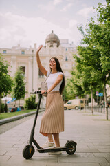 Young woman riding an electric scooter on a street