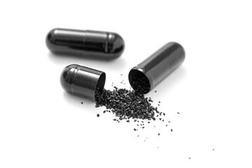 Closeup activated charcoal capsules isolated on white background