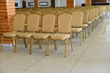 closeup the bunch yellow golden metal chairs in the row soft focus natural yellow brown background.