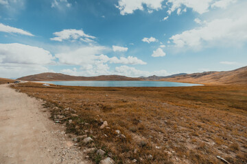 wide landscape view of Shausar lake in Deosai National Park on a sunny summer day in Pakistan